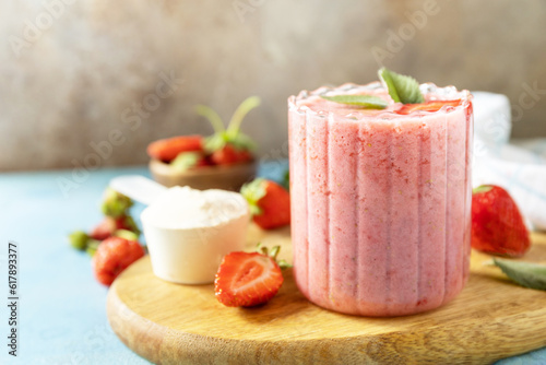 Fresh milk, strawberry drinks on wooden board on a stone background, protein shake with fresh berries. Copy space. photo