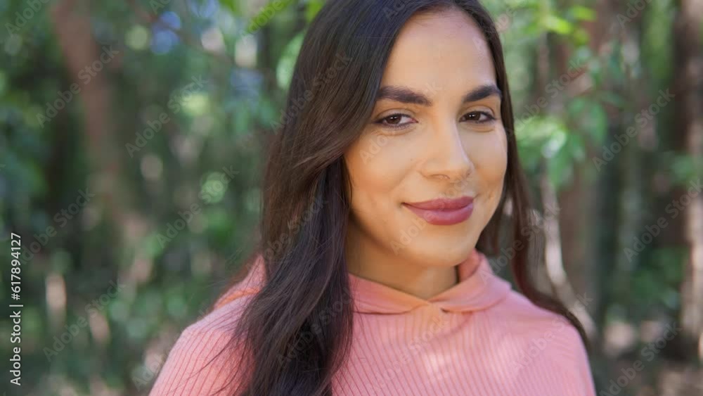 enjoy nature and outdoor. portrait of tranquil woman with a smile looking at camera in forest trail. enjoy nature and outdoor. portrait of tranquil woman with a smile looking at camera in forest trail.