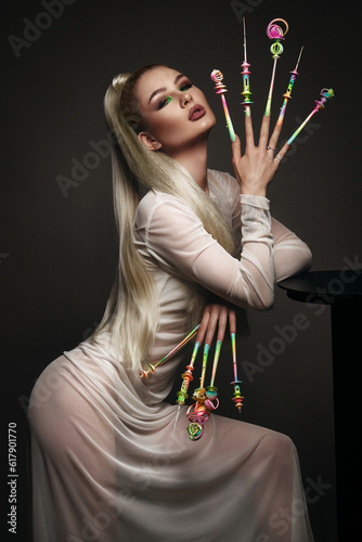 Portrait of a beautiful woman with art make-up in glamorous style, creative long nails. Design manicure. Beauty face.