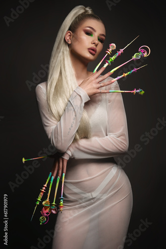 Portrait of a beautiful woman with art make-up in glamorous style, creative long nails. Design manicure. Beauty face. photo