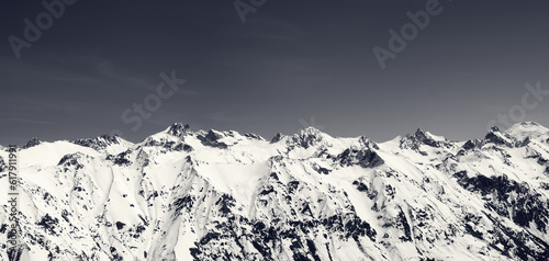 Panorama of snow covered mountains and blue sky at sun cold day
