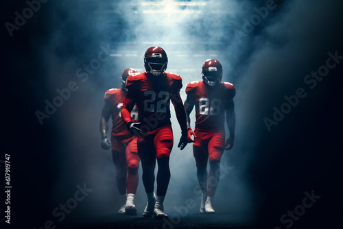 Three football players entering stadium with fog in background.