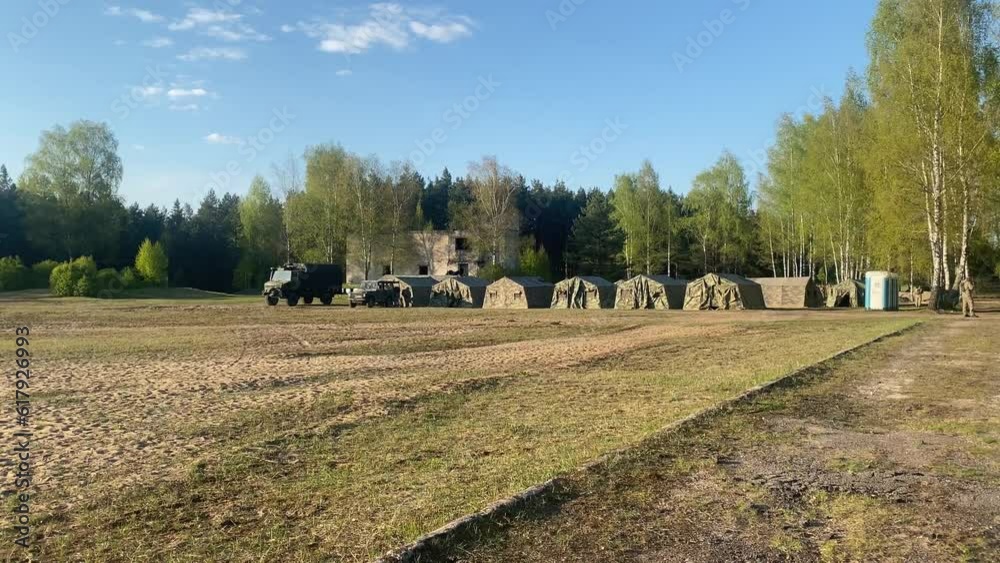 camouflage tents with truck isolated stand by forest in summer. Military base camp for exercise for young soldiers. Training and army lifestyle