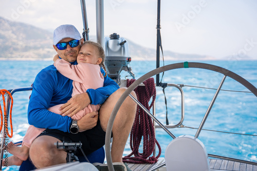 Father and daughter control sailing boat in the sea on boat or yacht. Family, adventure and skipper concept © dtatiana