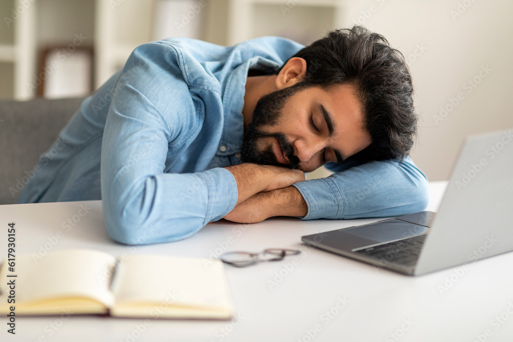 Sleeping At Work. Overworked freelancer guy napping at workplace at home office Sleeping At Work. Overworked freelancer guy napping at workplace at home office