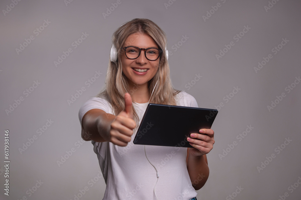 Portrait of happy woman holding thumbs up, isolated on gray background Portrait of happy woman holding thumbs up, isolated on gray background