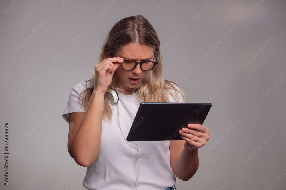 Young woman with glasses looking at tablet