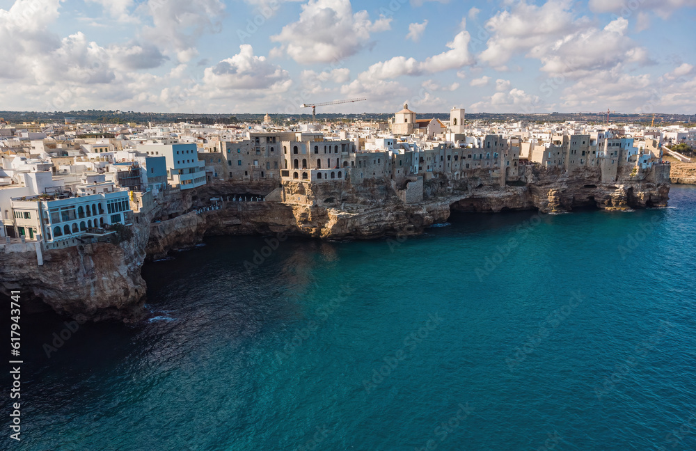 Aerial view of Polignano a Mare, a village built on the edge of the sandstone cliffs above the Adriatic Sea in Apulia, Italy.