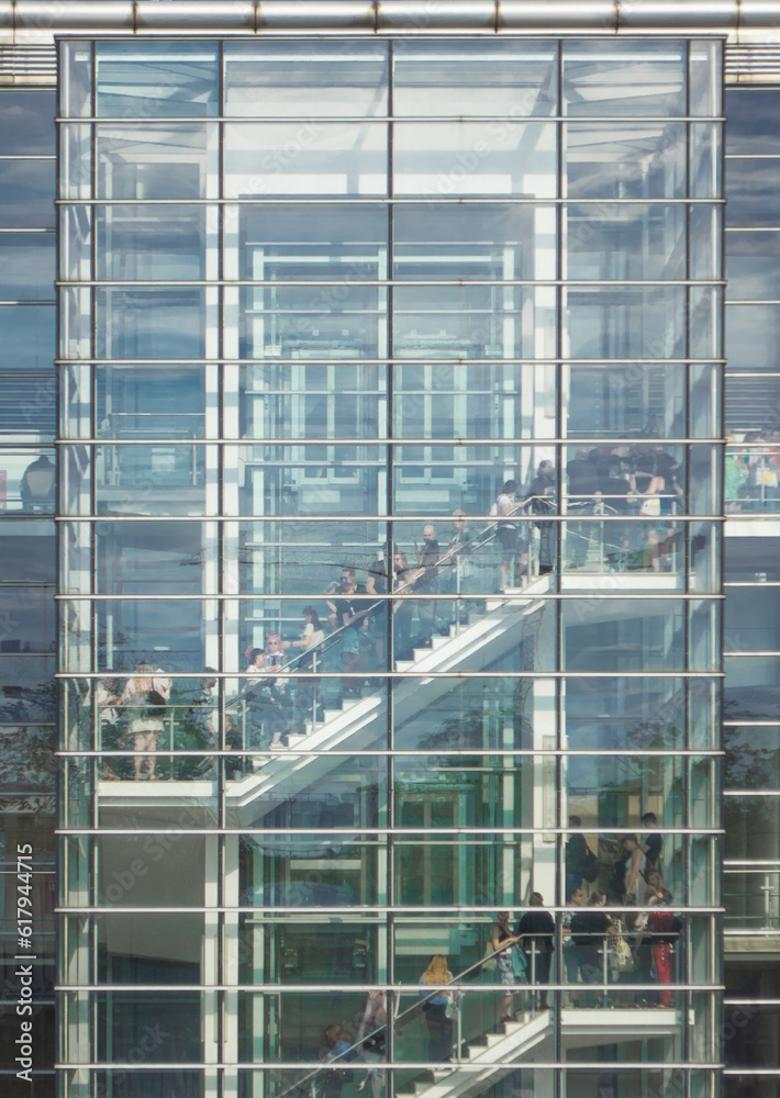 Obraz premium Glass skyscraper office staircase full of people queueing in line on the stairs