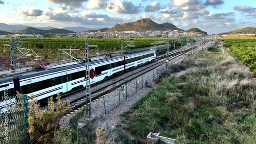 Train on railway. Spain regional commuter train in motion on railway. Spanish National Rail Network. Travel by train in European countries. Train against of mountains drive on railway photo