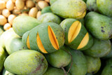 Mangoes cut to show inside and outside of fruit in street market.
