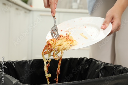 Obraz na plátně Woman throwing pasta into bin indoors, closeup