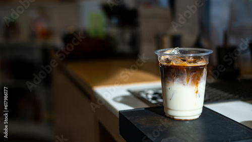 Iced coffee in plastic cup on wood table in coffee shop.