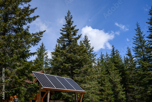 Remote ecotourism camp in the forest powered by an array of solar panels, clean energy