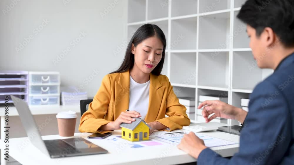 Real estate broker agent presenting and consult to customer to decision making sign insurance form agreement, home model, concerning mortgage loan offer Real estate broker agent presenting and consult to customer to decision making sign insurance form agreement, home model, concerning mortgage loan offer