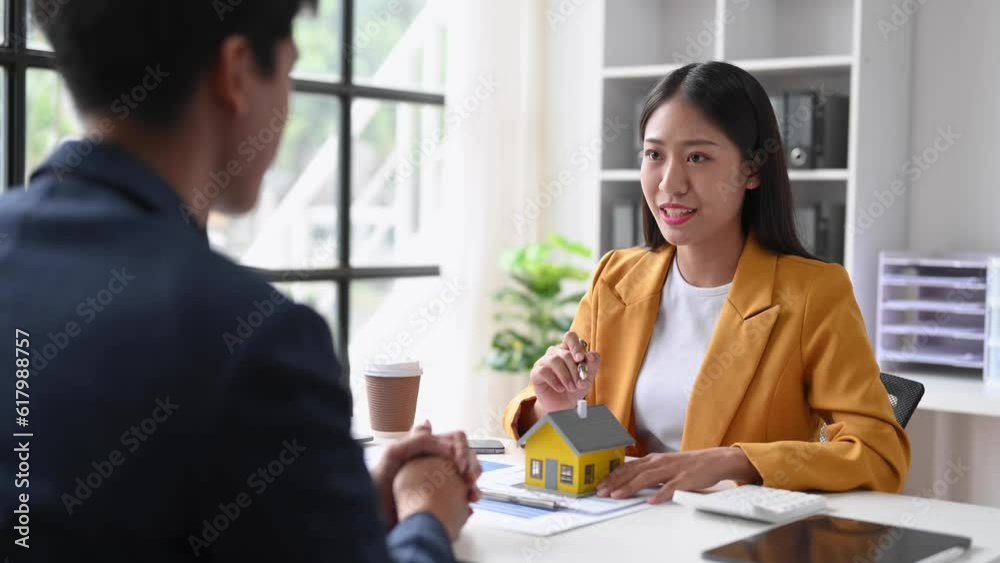 Real estate broker agent presenting and consult to customer to decision making sign insurance form agreement, home model, concerning mortgage loan offer Real estate broker agent presenting and consult to customer to decision making sign insurance form agreement, home model, concerning mortgage loan offer