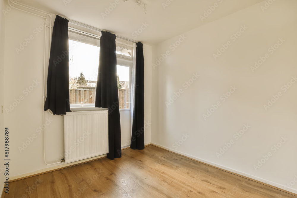 Fototapeta premium an empty room with wooden floors and white walls, black drapes hanging from the window to the right side