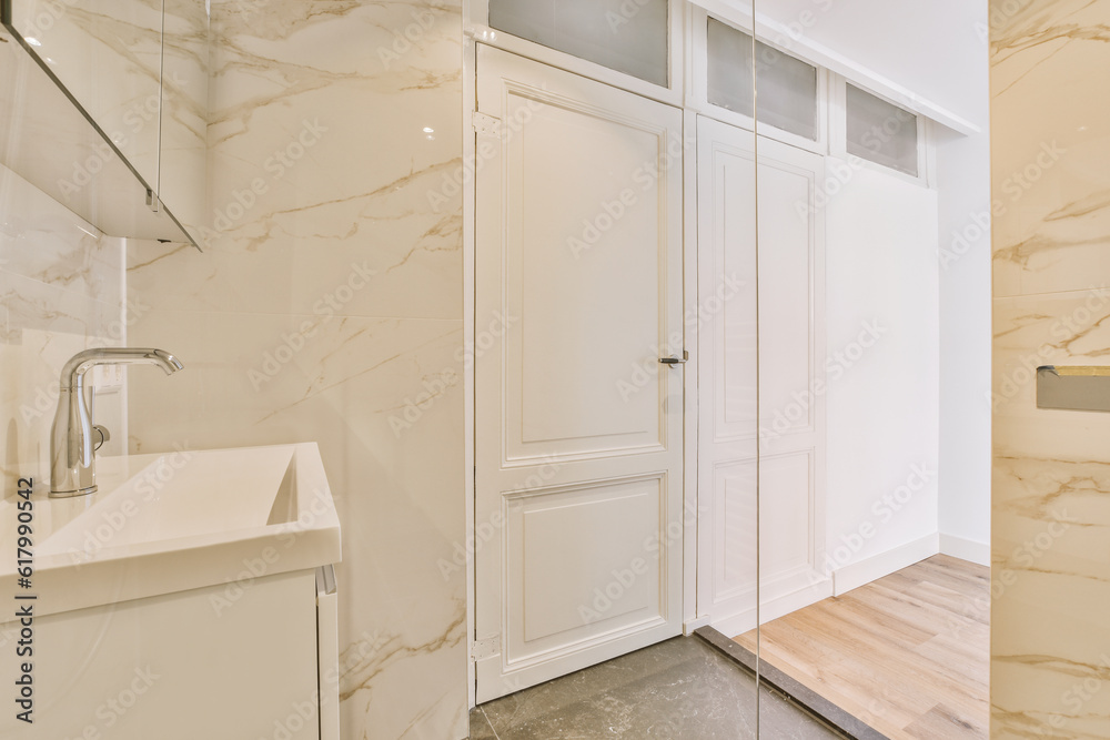 a modern bathroom with marble walls and flooring, including a white wash basin bowl on the right handwasher a modern bathroom with marble walls and flooring, including a white wash basin bowl on the right handwasher