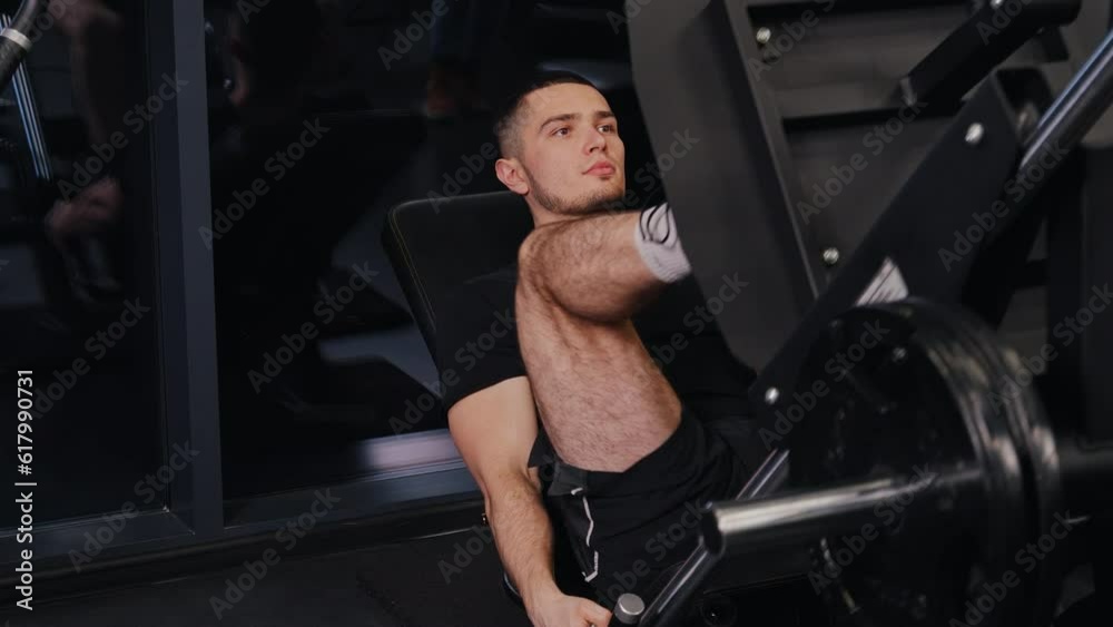 leg press, Machine workout, Athletic man. Attractive male trainer gym performs leg press exercises. leg press, Machine workout, Athletic man. Attractive male trainer gym performs leg press exercises.