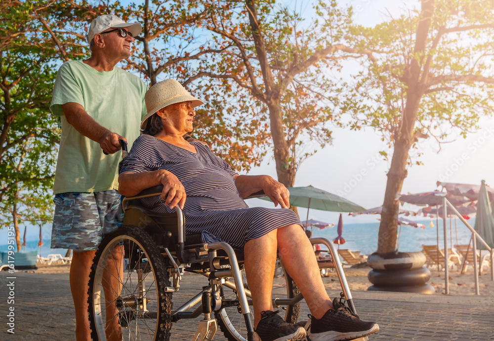 A senior carries his wife on a wheelchair