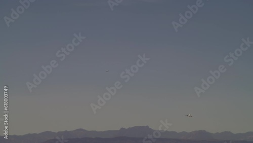 Commercial aircraft taking off and going up in a beautiful scenery during sunset time and amazing mounting break ground las Vegas airport Nevada USA