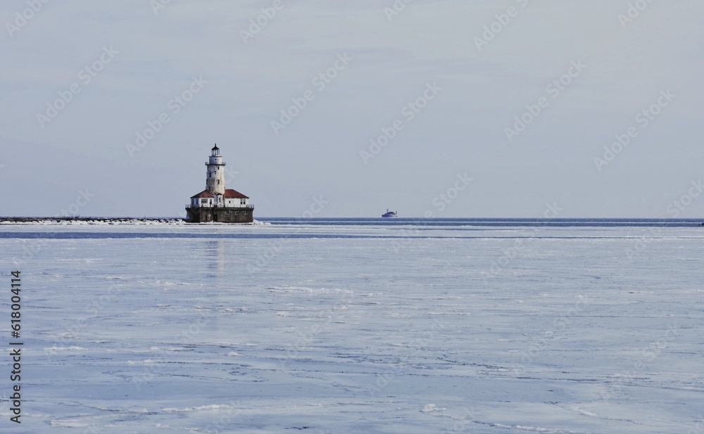 lighthouse on the shore of the river over the ice lake