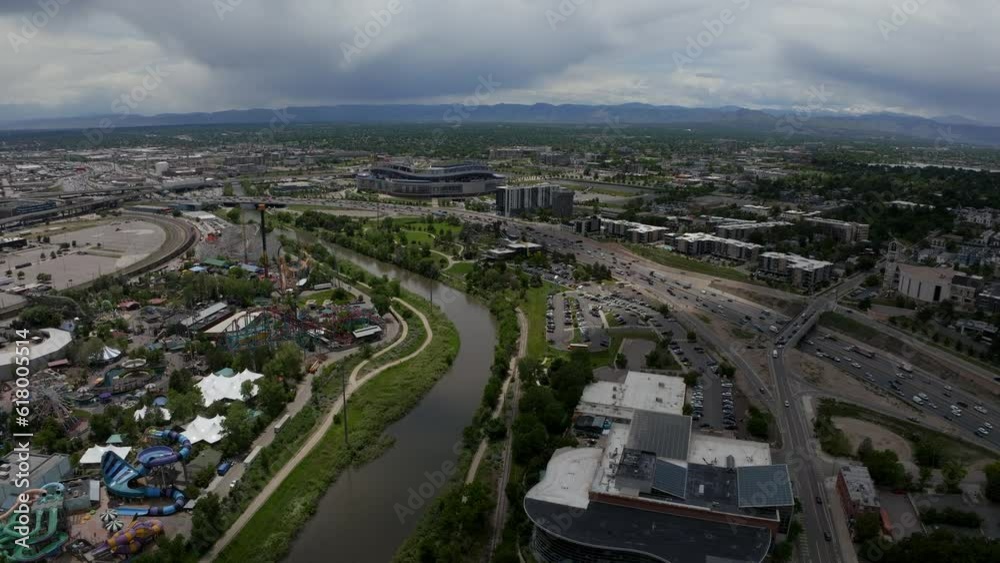 Downtown Denver Aerial Drone cinematic Mile High Stadium South Platte River Elitch Gardens cityscape with foothills Rocky Mountain Landscape Colorado cars traffic spring summer forward movement Downtown Denver Aerial Drone cinematic Mile High Stadium South Platte River Elitch Gardens cityscape with foothills Rocky Mountain Landscape Colorado cars traffic spring summer forward movement