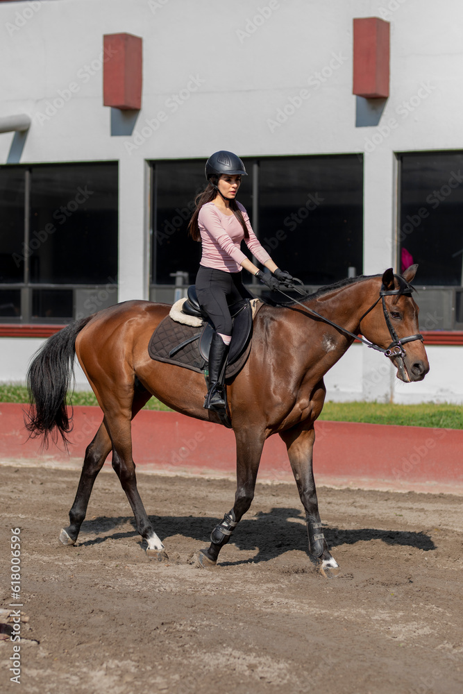 Vertical photo of a young Latina woman riding a horse Vertical photo of a young Latina woman riding a horse