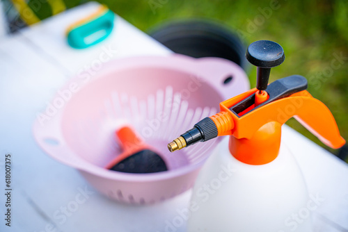 Garden pump sprayer with orange handle close-up. Universal garden sprayer for plant treatment