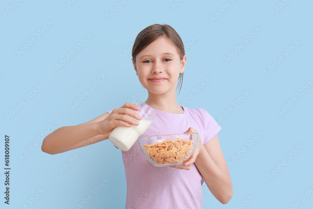 Little girl with milk and cornflakes on light blue background Little girl with milk and cornflakes on light blue background