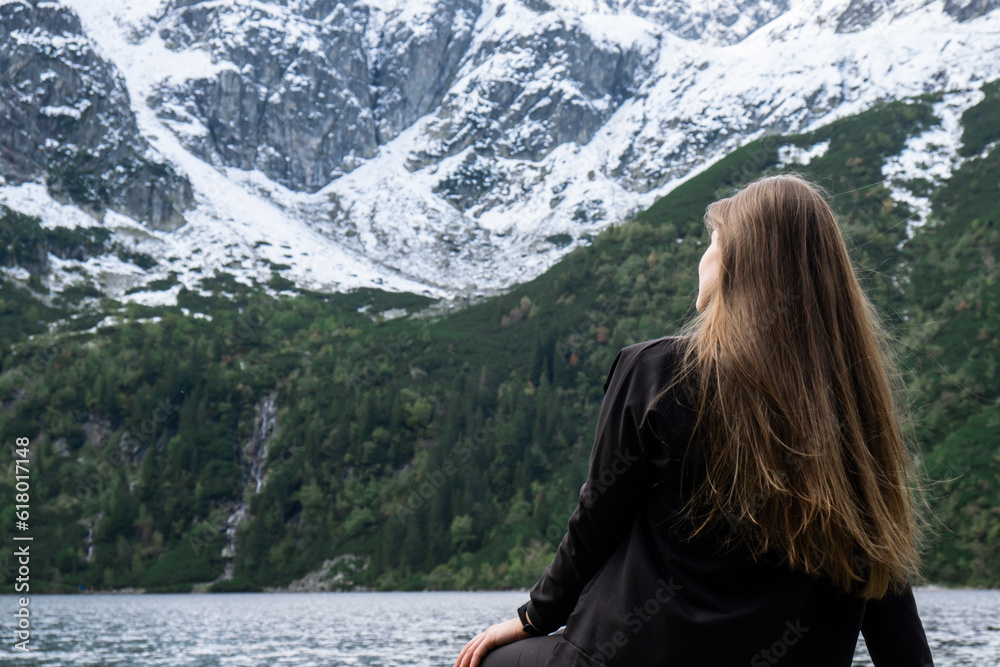 Naklejka premium Young woman enjoying nature in Morskie Oko Snowy Mountain Hut in Polish Tatry mountains Zakopane Poland. Naturecore aesthetic beautiful green hills. Mental and physical wellbeing Travel outdoors