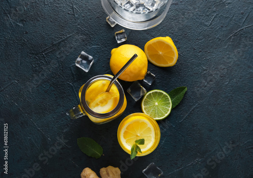 Glass and mason jar of infused water with lemon on black background