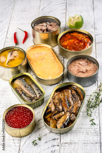 Canned fish and seafood on wooden kitchen table. Copy space