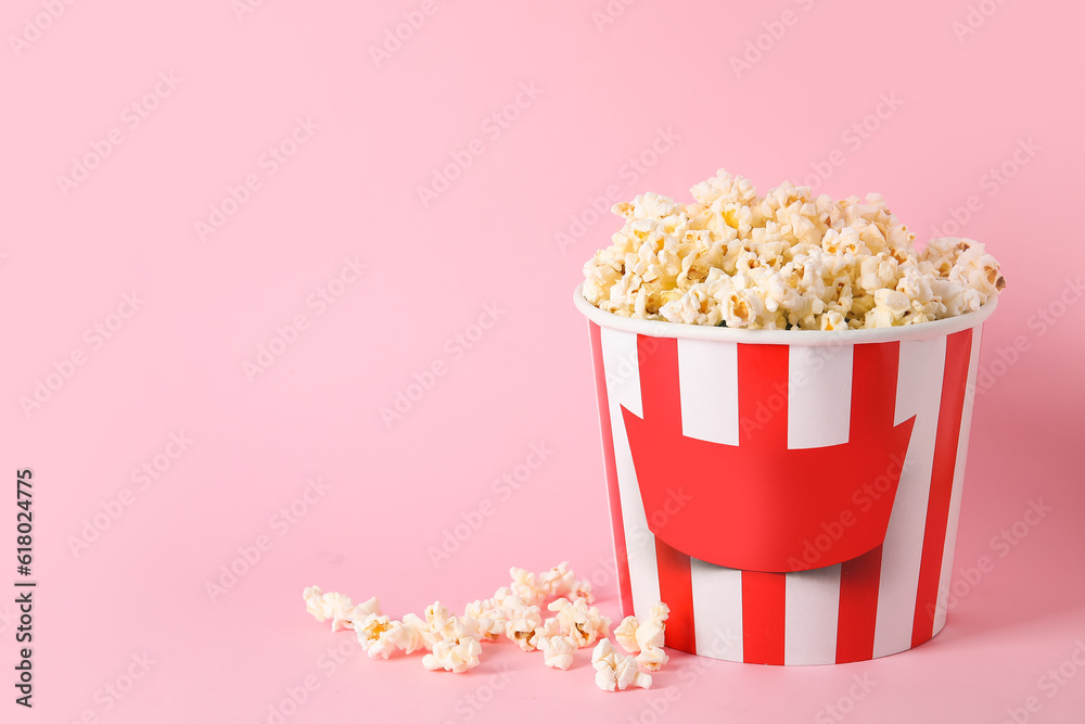 Bucket with tasty popcorn on pink background Bucket with tasty popcorn on pink background