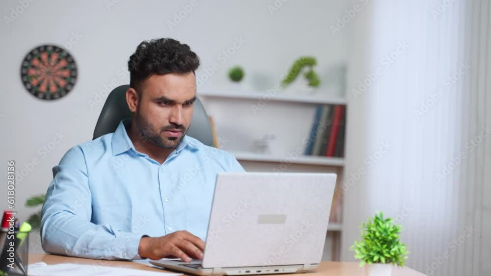 Indian businessman busy working on laptop while sitting at office - concept of employment, career and