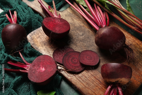 Wooden board of fresh beets on table