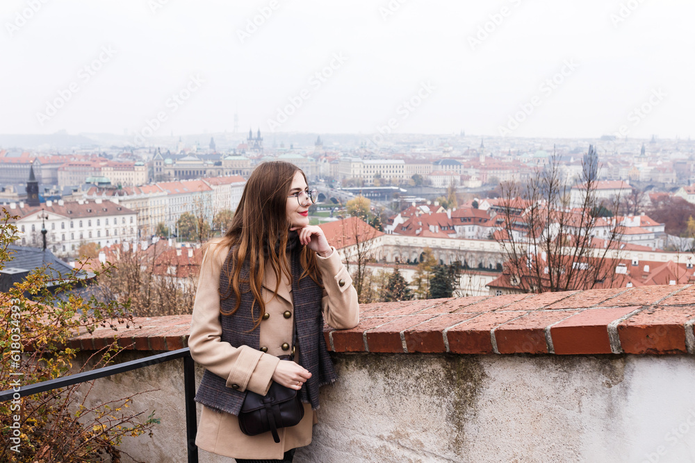 brown-haired woman in a coat on the streets of a European city