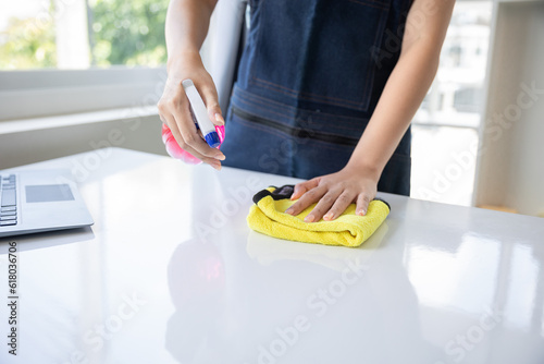 Close-up shot of woman hands cleaning table with yellow rags in office office cleaning woman