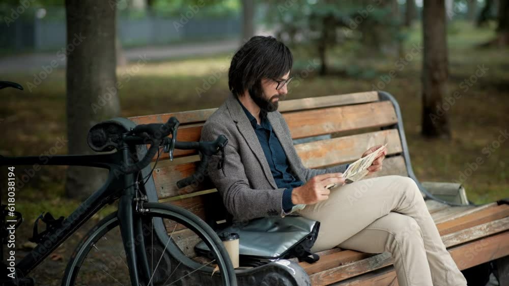 Man sitting on bench and reading newspaper Man sitting on bench and reading newspaper