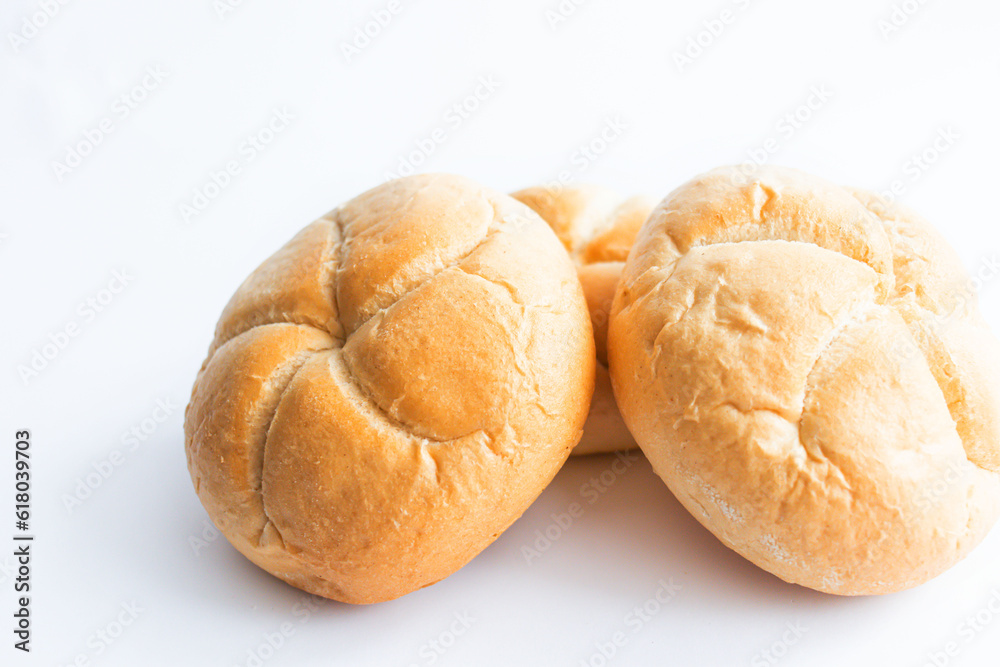 Bread rolls with wheat ears. on a white background. Close-up.