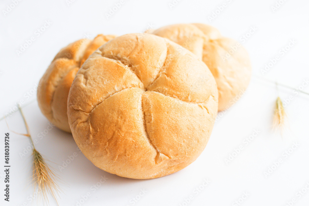 Bread rolls with wheat ears. on a white background. Close-up. Bread rolls with wheat ears. on a white background. Close-up.