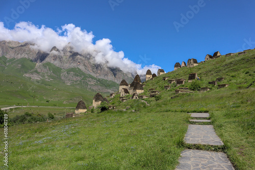 city of the dead Dargavs necropolis with landscape of the mountains with sky and clouds on the background