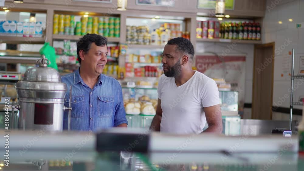 Joyful Candid Interaction Between Diverse Friends at Cafeteria Counter, Men Engaged in Conversation in Deli Restaurant