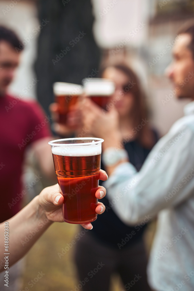 Group of friends enjoying cold beer at a backyard party.