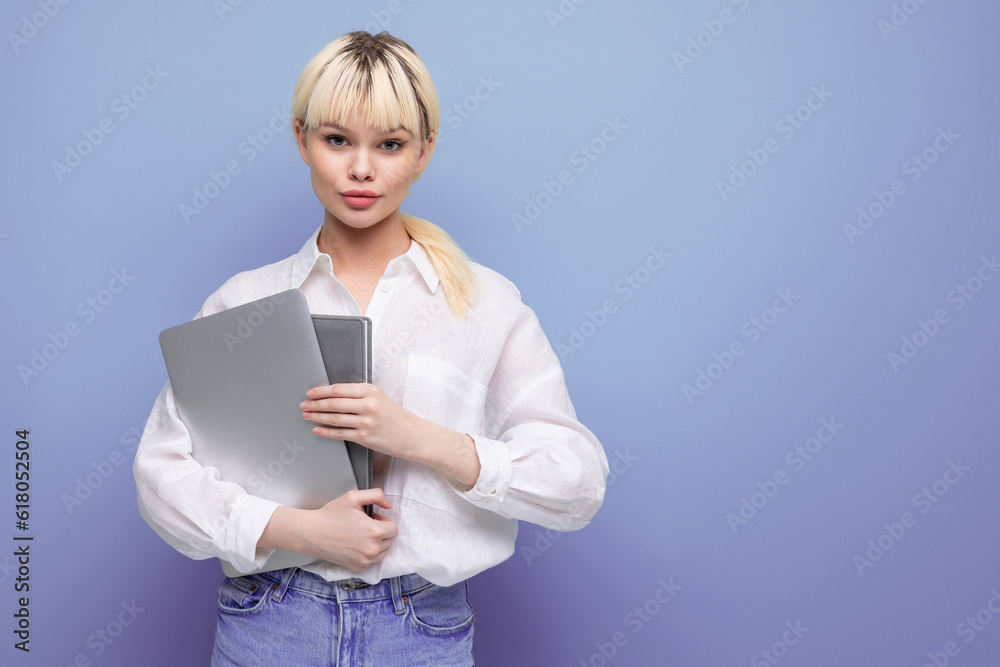 portrait of a young pretty blond secretary woman dressed in a white blouse with a working laptop and documents portrait of a young pretty blond secretary woman dressed in a white blouse with a working laptop and documents