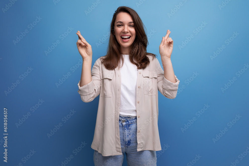 active 30s dark-haired woman in a beige shirt on a blue background active 30s dark-haired woman in a beige shirt on a blue background