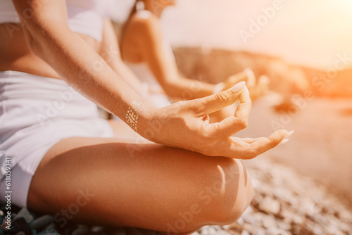 Woman sea yoga. Happy women meditating in yoga pose on the beach, ocean and rock mountains. Motivation and inspirational fit and exercising. Healthy lifestyle outdoors in nature, fitness concept.