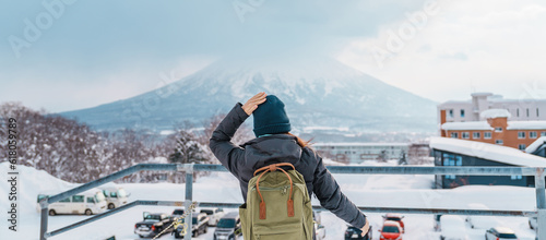 Woman tourist Visiting in Niseko, Traveler in Sweater sightseeing Yotei Mountain with Snow in winter season. landmark and popular for attractions in Hokkaido, Japan. Travel and Vacation concept photo