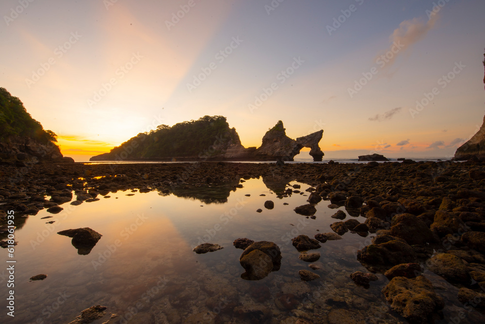 Beautiful sunrise scenery of unique rock island at atuh beach nusa penida, bali