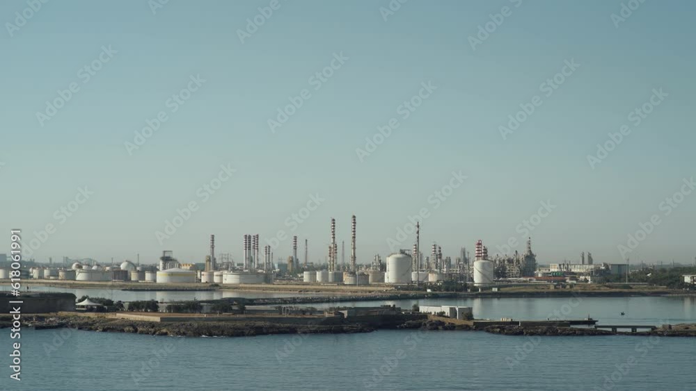 Large oil processing factory, view of the steel pipes and tanks near the lake, industrial structure of the plant, coastal zone, view of the oil storage. Large oil processing factory, view of the steel pipes and tanks near the lake, industrial structure of the plant, coastal zone, view of the oil storage.